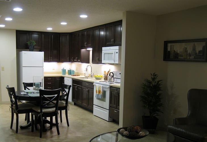 A kitchen with dark cabinets and white appliances.