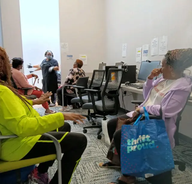 A group of people sitting in chairs and talking.