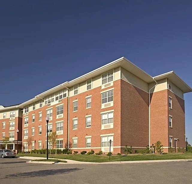 A large brick building with cars parked in front of it.