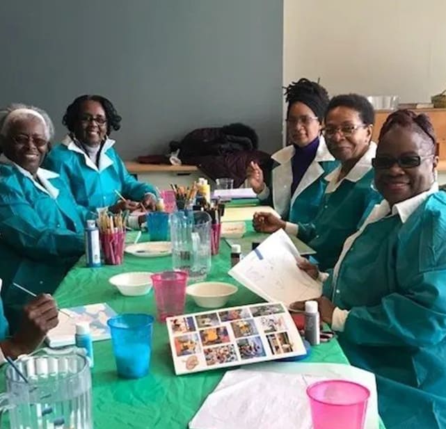 A group of people sitting at a table with plates.