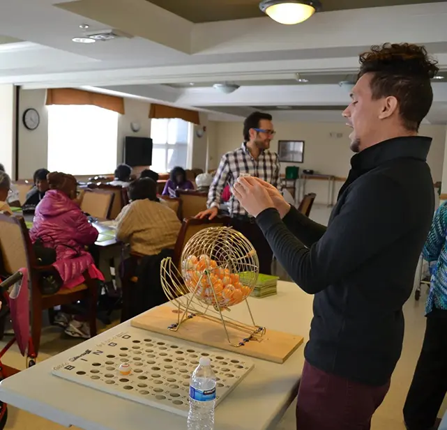 A man standing in front of a table with people.