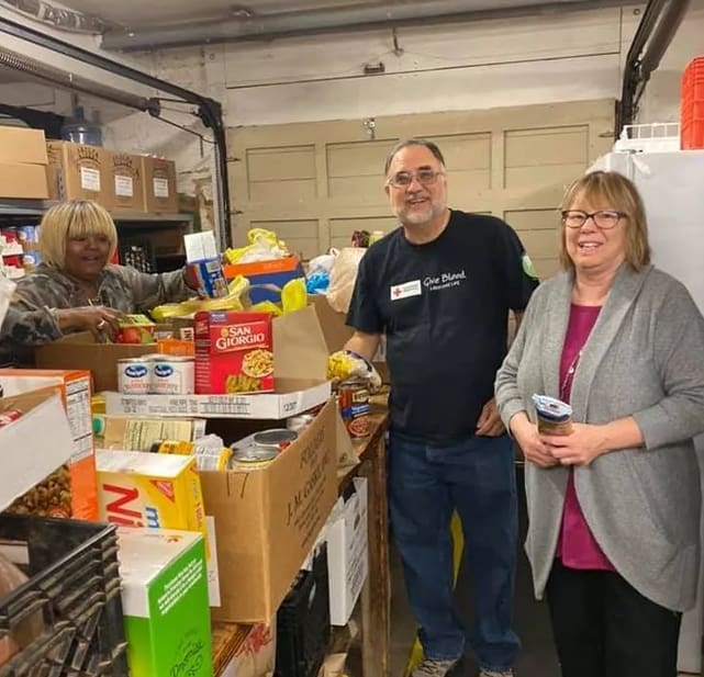 A man and woman standing in front of boxes.