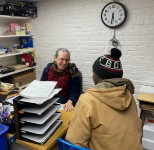 Two people sitting at a table with papers on it