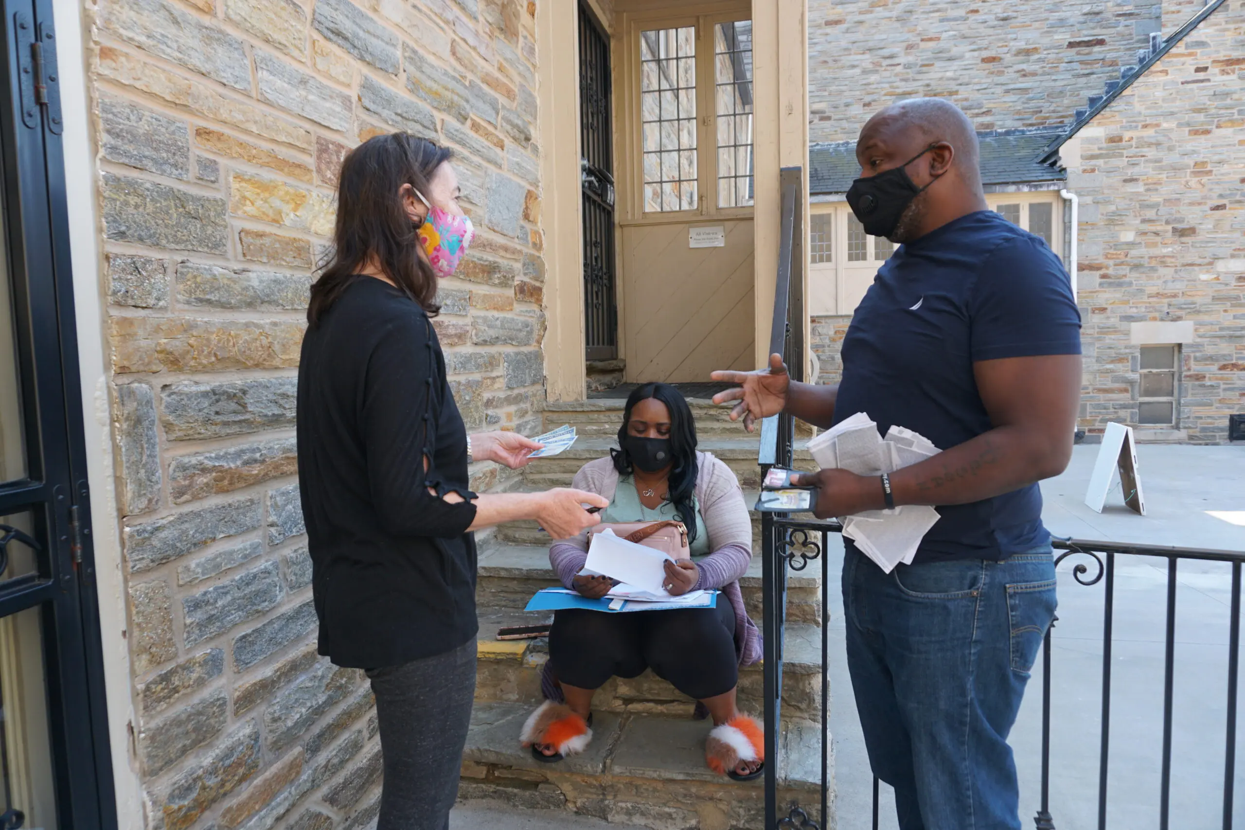 A group of people standing on steps near a building.