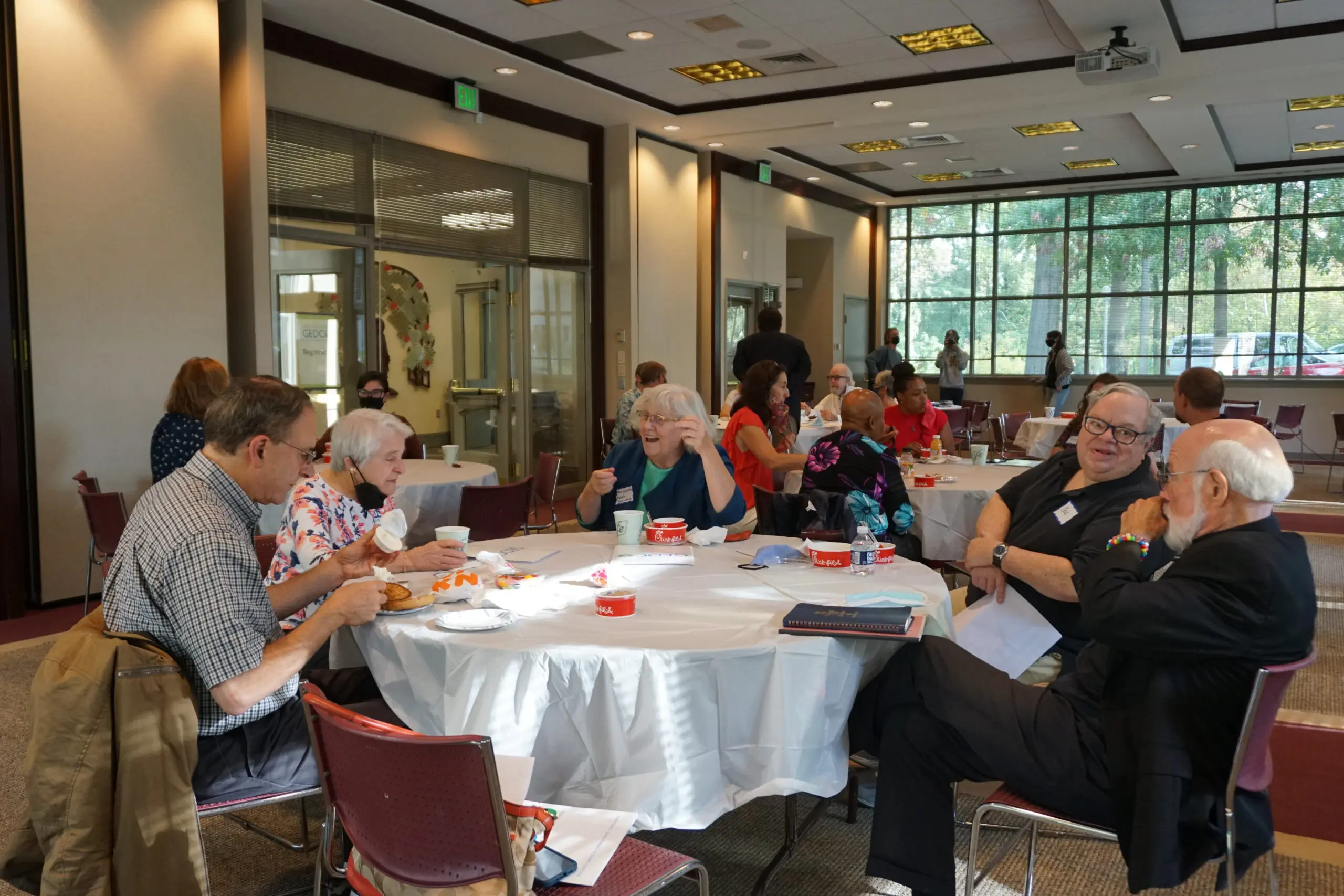 A group of people sitting at tables eating food.