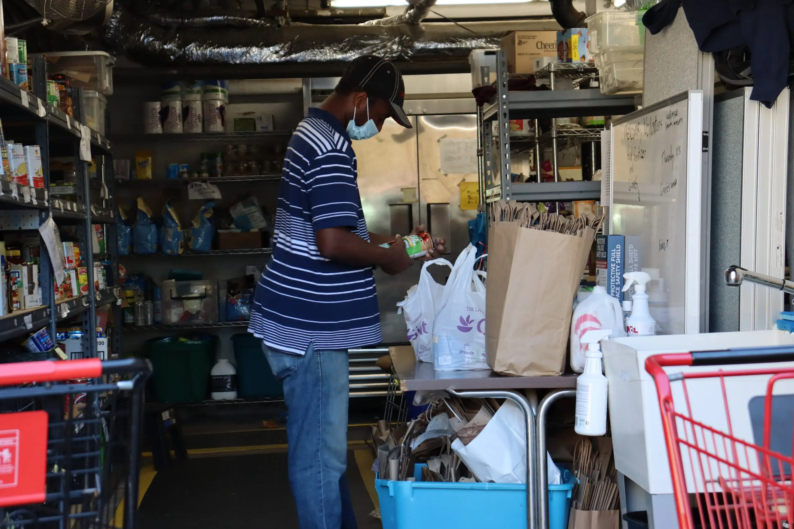 A man in striped shirt working inside of a store.