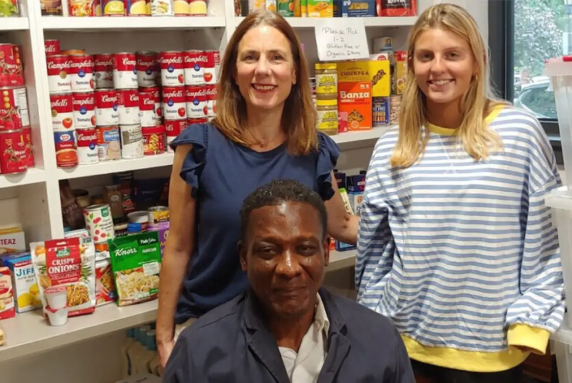 Three people smiling in a food pantry.